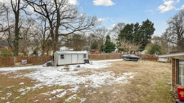 snowy yard featuring a storage shed