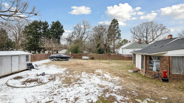 yard covered in snow with a storage unit