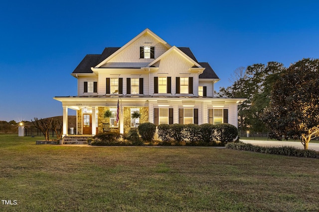 view of front of home with a porch and a yard