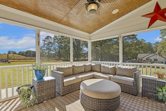 sunroom featuring wood ceiling, vaulted ceiling, ceiling fan, and plenty of natural light