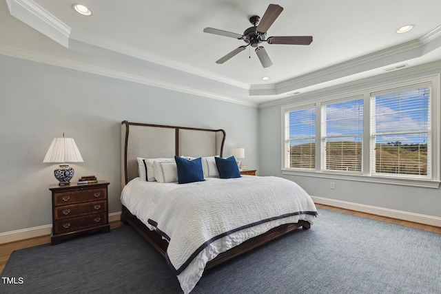 bedroom featuring ceiling fan, ornamental molding, dark hardwood / wood-style flooring, and a raised ceiling