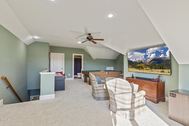 carpeted living room with ceiling fan and vaulted ceiling