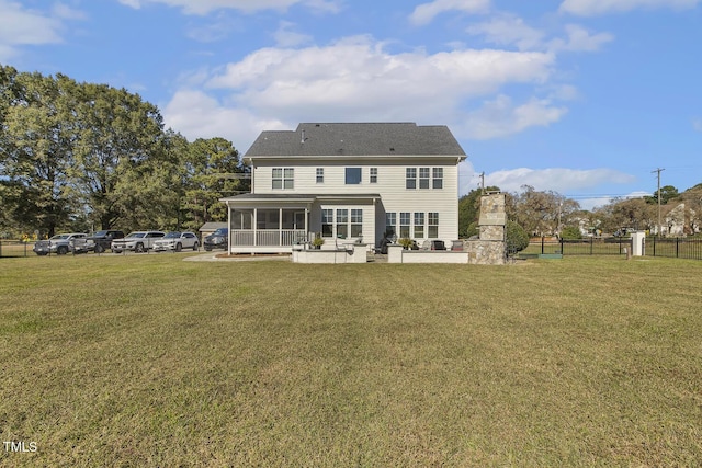 rear view of property with a yard, a patio area, a sunroom, and an outdoor stone fireplace