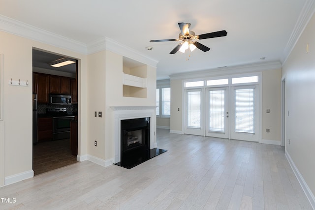 unfurnished living room featuring ornamental molding, ceiling fan, and light hardwood / wood-style floors