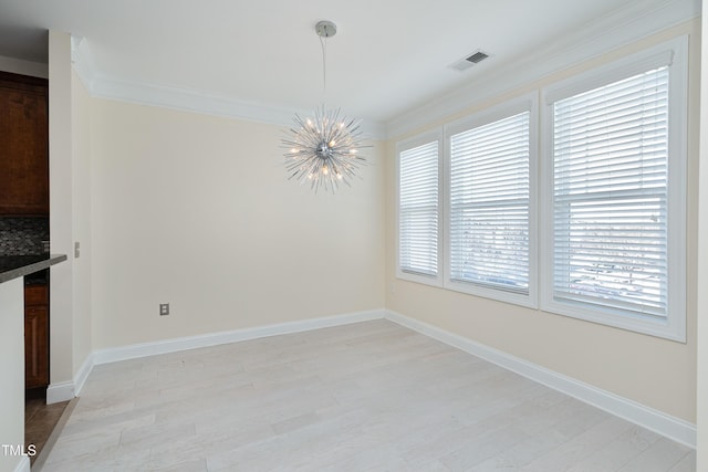 unfurnished dining area with crown molding and an inviting chandelier