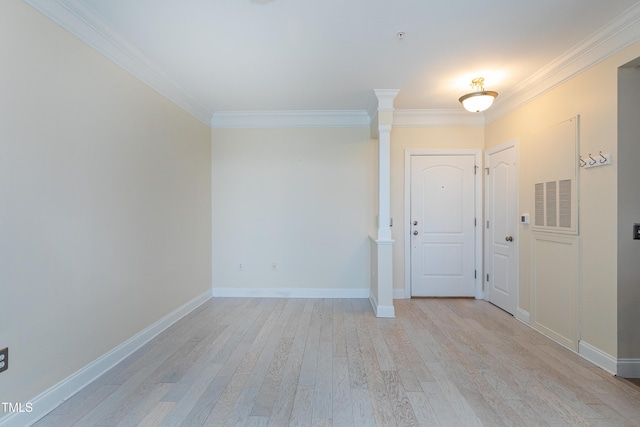 foyer entrance featuring crown molding, light hardwood / wood-style flooring, and decorative columns