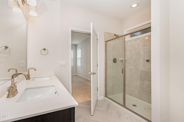 full bathroom featuring double vanity, a sink, and a shower stall