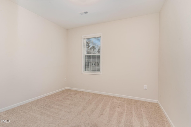 unfurnished room featuring visible vents, light carpet, and baseboards