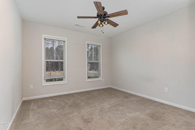 unfurnished room featuring carpet floors, baseboards, visible vents, and ceiling fan