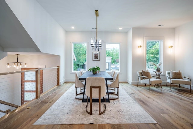 dining area with an inviting chandelier and light hardwood / wood-style flooring