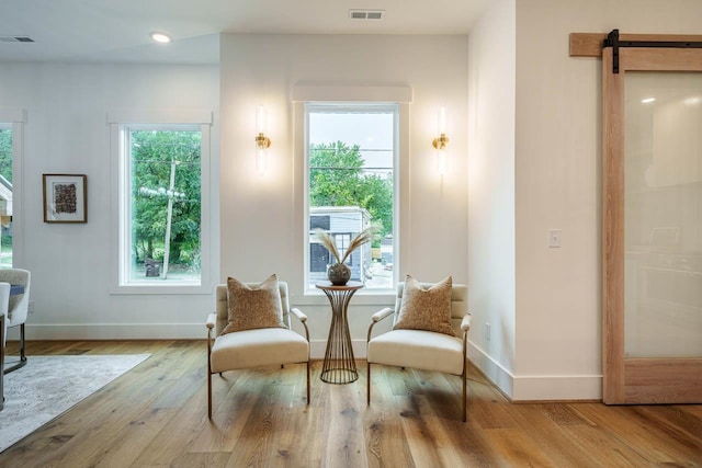 sitting room featuring a barn door and light wood-type flooring