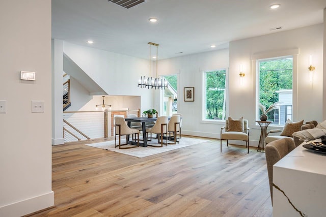 dining area featuring a notable chandelier and light wood-type flooring