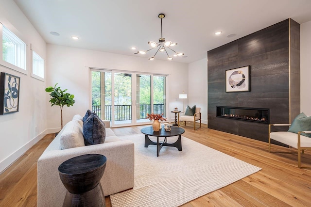 living room featuring hardwood / wood-style floors, a fireplace, and a chandelier