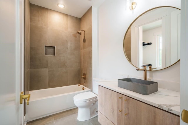 full bathroom featuring tiled shower / bath, vanity, toilet, and tile patterned floors