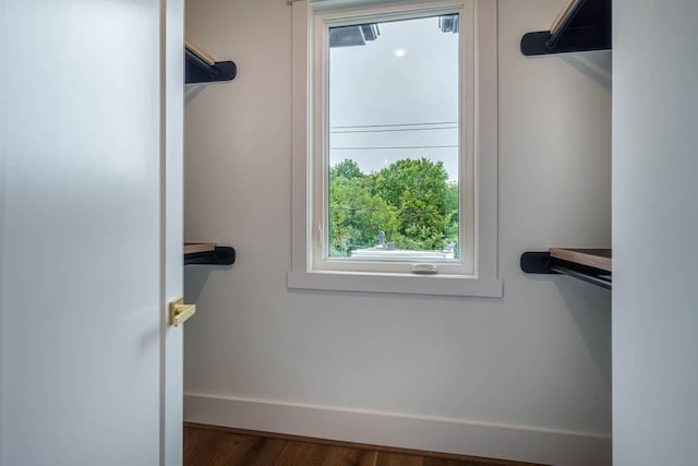 walk in closet with dark hardwood / wood-style flooring