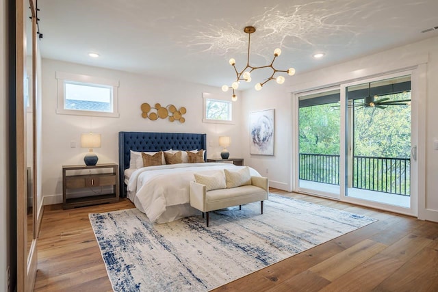 bedroom featuring a notable chandelier, light hardwood / wood-style floors, and access to outside