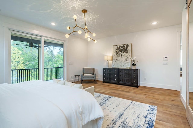 bedroom with hardwood / wood-style flooring, access to outside, and a chandelier