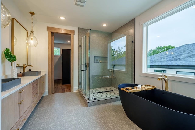 bathroom featuring an enclosed shower, vanity, and a wealth of natural light