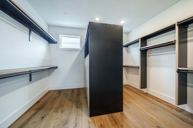 walk in closet with light hardwood / wood-style flooring