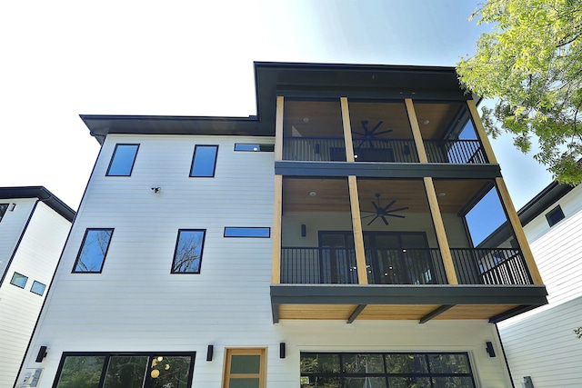 back of property with a balcony and ceiling fan