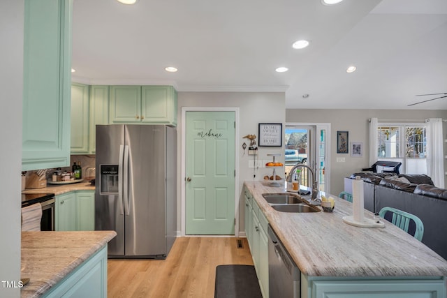 kitchen featuring green cabinetry, appliances with stainless steel finishes, sink, and light wood-type flooring