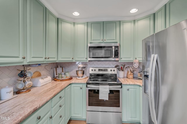 kitchen featuring tasteful backsplash, green cabinetry, and stainless steel appliances