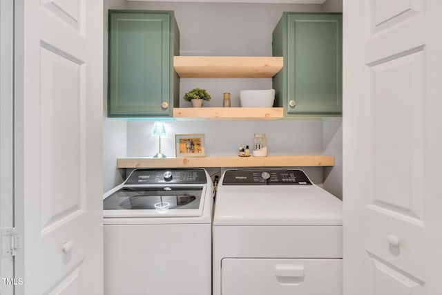 clothes washing area featuring cabinets and separate washer and dryer