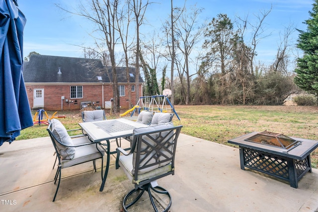 view of patio featuring a playground and a fire pit