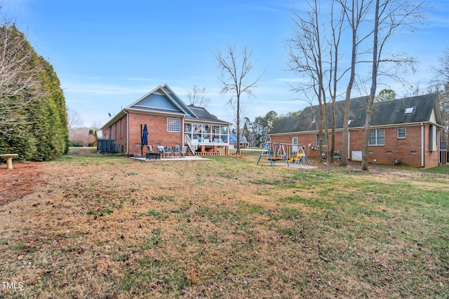 view of yard with a patio area, a sunroom, and a playground