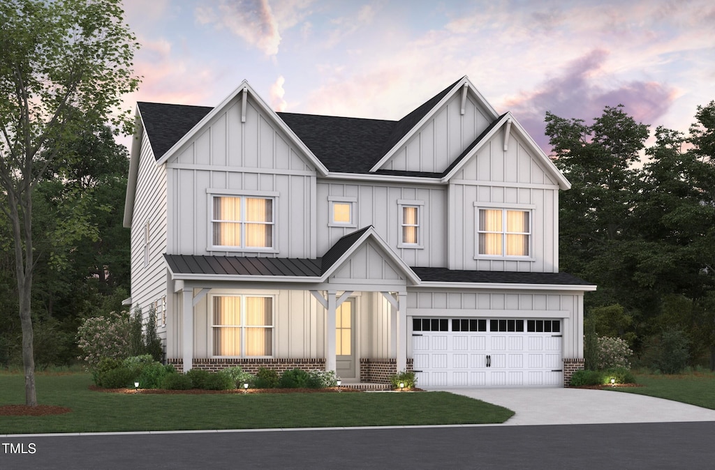 view of front of home with a garage and a lawn