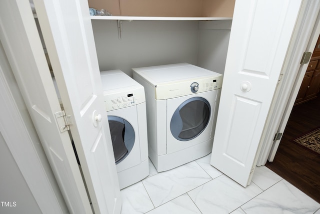 laundry room with washer and dryer, laundry area, and marble finish floor