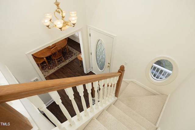 stairs featuring baseboards and an inviting chandelier