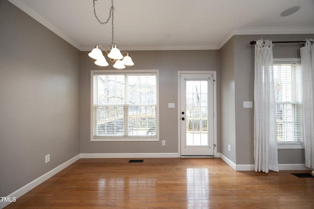 doorway featuring light wood-type flooring, a chandelier, and crown molding