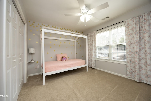 carpeted bedroom with ceiling fan and a closet