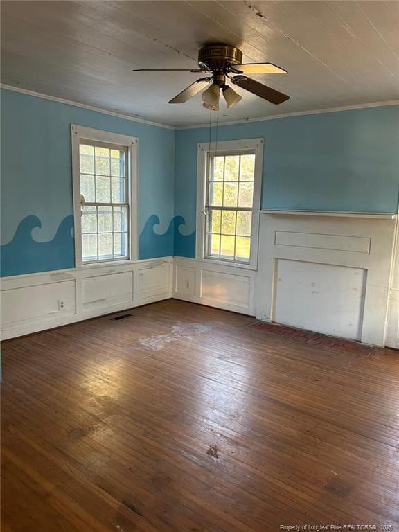 empty room featuring ornamental molding, dark hardwood / wood-style floors, and a wealth of natural light