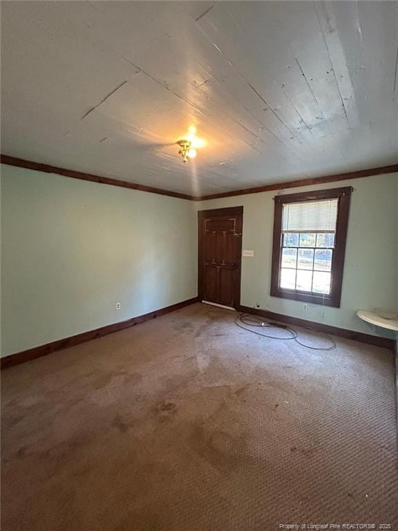 carpeted spare room featuring crown molding