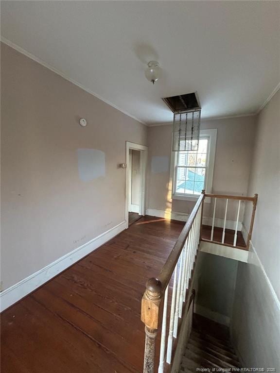 staircase with ornamental molding and hardwood / wood-style floors