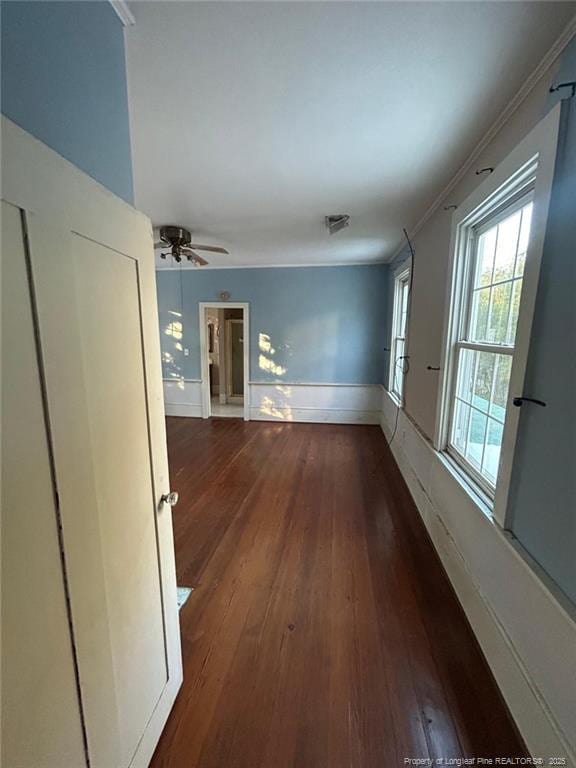 corridor featuring ornamental molding and dark hardwood / wood-style floors