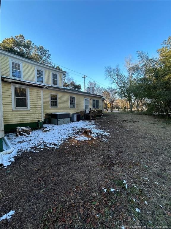 snow covered back of property with central air condition unit