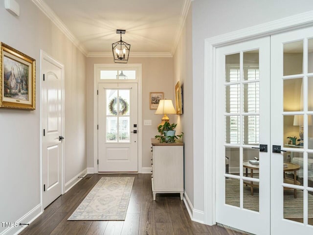 foyer entrance featuring dark wood-type flooring, a wealth of natural light, a notable chandelier, and french doors