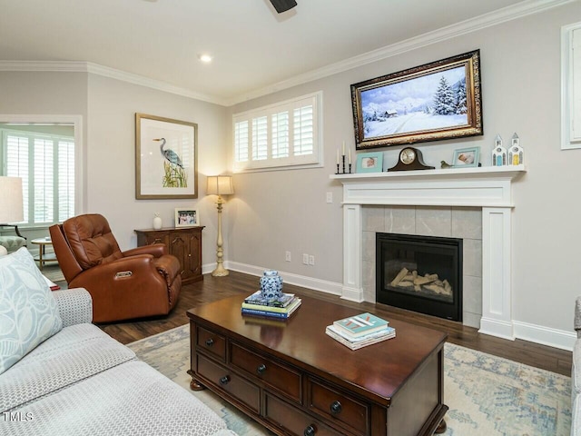 living room featuring a tiled fireplace, crown molding, and plenty of natural light