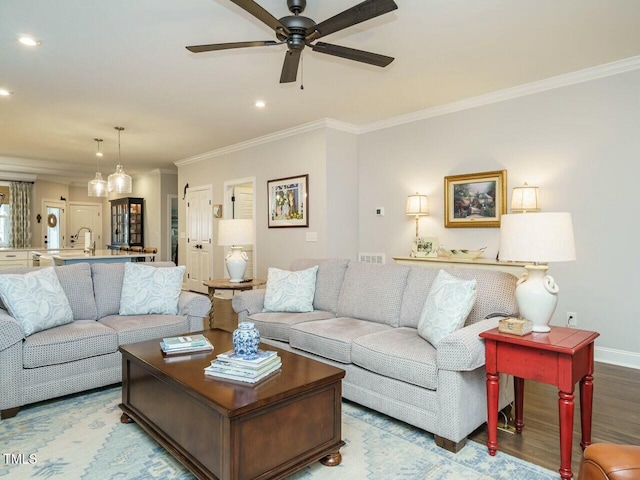 living room featuring crown molding, ceiling fan, and light wood-type flooring