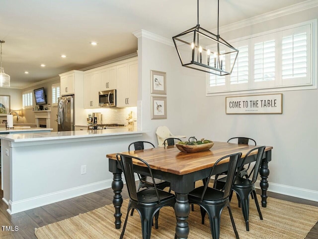 dining space featuring dark hardwood / wood-style flooring and crown molding