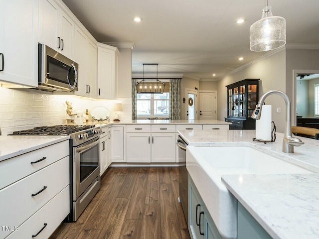 kitchen with white cabinetry, decorative light fixtures, and appliances with stainless steel finishes