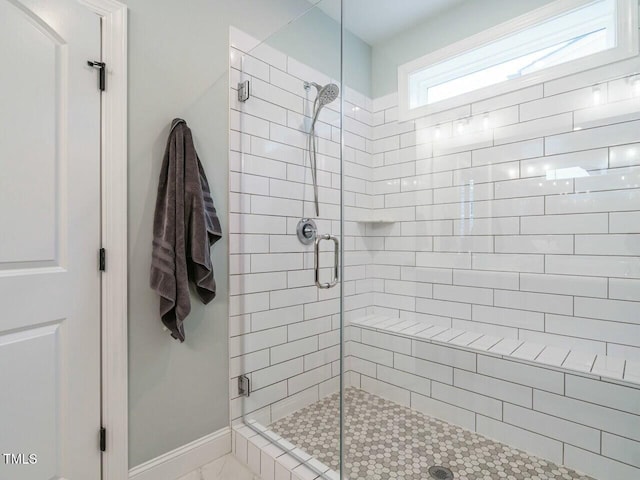 bathroom with a shower with door