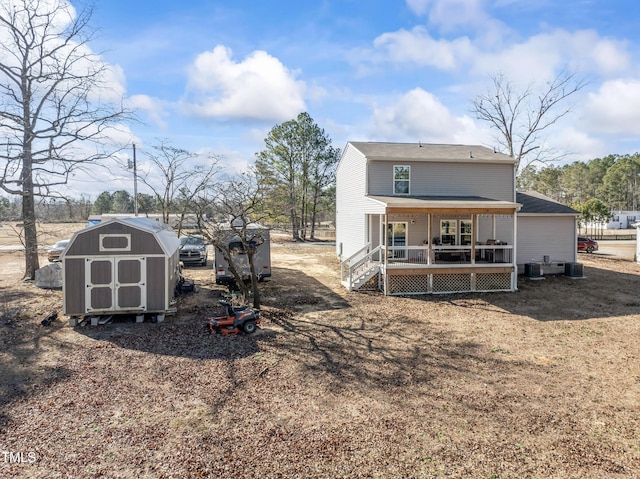 back of house with a storage unit and a porch