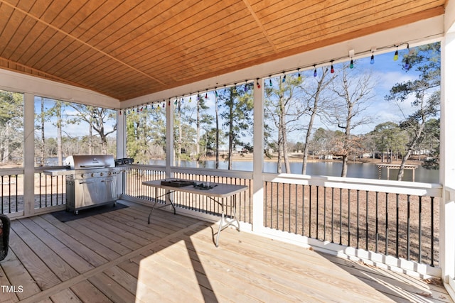 wooden terrace with grilling area and a water view