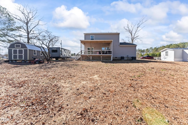 back of property with a storage unit and a porch