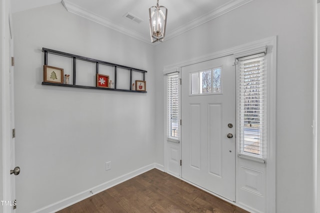 entrance foyer featuring dark hardwood / wood-style flooring, a notable chandelier, and crown molding