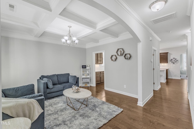 living room featuring dark wood-type flooring, coffered ceiling, beamed ceiling, ornamental molding, and a chandelier